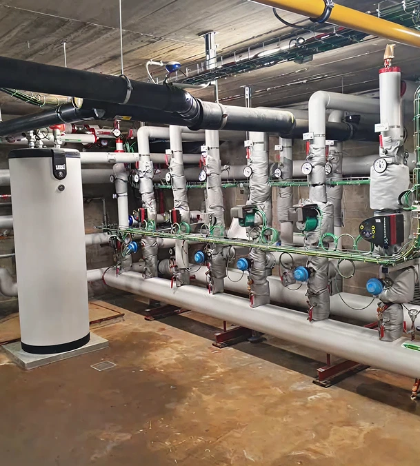 Local technique avec installation de chauffage, pompes de circulation et réseau hydraulique.